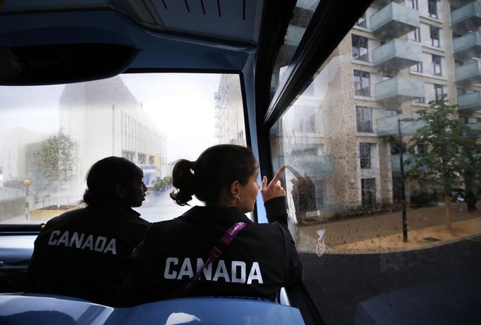 Canadian women's soccer team players Robyn Gayle (L) and Rhian Wilkinson look out the window from a double-decker bus as they arrive at the Athletes' Village at the Olympic Park in London July 18, 2012. REUTERS/Jae C. Hong/Pool (BRITAIN - Tags: SPORT OLYMPICS SOCCER) Published: Čec. 18, 2012, 6:45 odp.