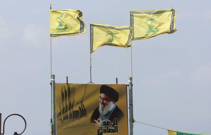 Vlajka libanonského hnutí Hizballáh a plakát s lídrem organizace Hasanem Nasralláhem