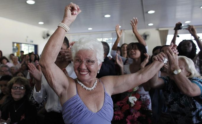 A contestant dances next to relatives and friends during a beauty contest for elderly women, in honour of Mother's Day, in Sao Paulo May 10, 2012. The event was held to promote greater self-esteem among senior citizens, according to organizer Nilton Guedes. REUTERS/Nacho Doce (BRAZIL - Tags: SOCIETY) Published: Kvě. 11, 2012, 3:09 dop.