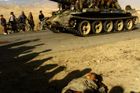ZAČÁTKY - Afghánští bojovníci projíždějí na tanku T-62 kolem mrtvých těl. Snímek byl pořízen na silnici 3 km severně od Kábulu. 13. listopad 2001.