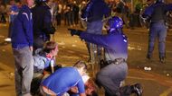 Fanoušci Rangers se snaží pomoci svému kamarádovi zraněnému při střetech s policií.