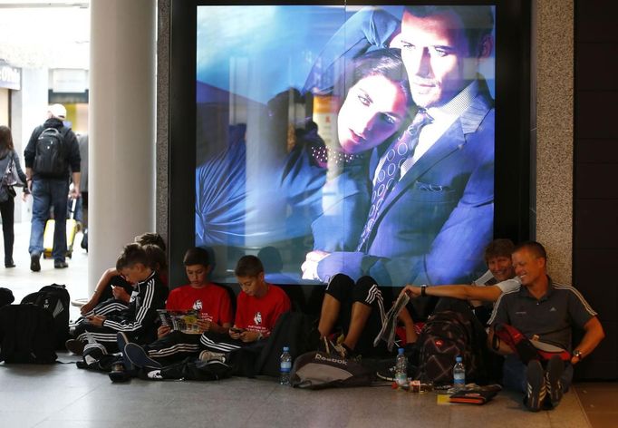 Stranded youth soccer team members sit on the floor as they wait for flight informations at the Fraport airport in Frankfurt, August 31, 2012. Lufthansa cancelled 64 flights at its main hub Frankfurt on Friday as cabin crew began the first of a series of strikes over pay and cost cuts in a busy holiday season. The eight-hour industrial action, following the breakdown of 13 months of negotiations between Germany's largest airline and trade union UFO, is due to end at 1100 GMT on Friday. REUTERS/Kai Pfaffenbach (GERMANY - Tags: BUSINESS EMPLOYMENT CIVIL UNREST) Published: Srp. 31, 2012, 9:26 dop.