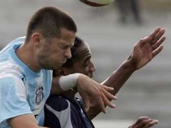 Frederic Thomas z AJ Auxerre v souboji s Vladimirem Bozovicem z OFK Bělehrad ve druhém předkole Poháru UEFA