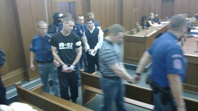 Čtveřice obviněných vchází do soudní místnosti
