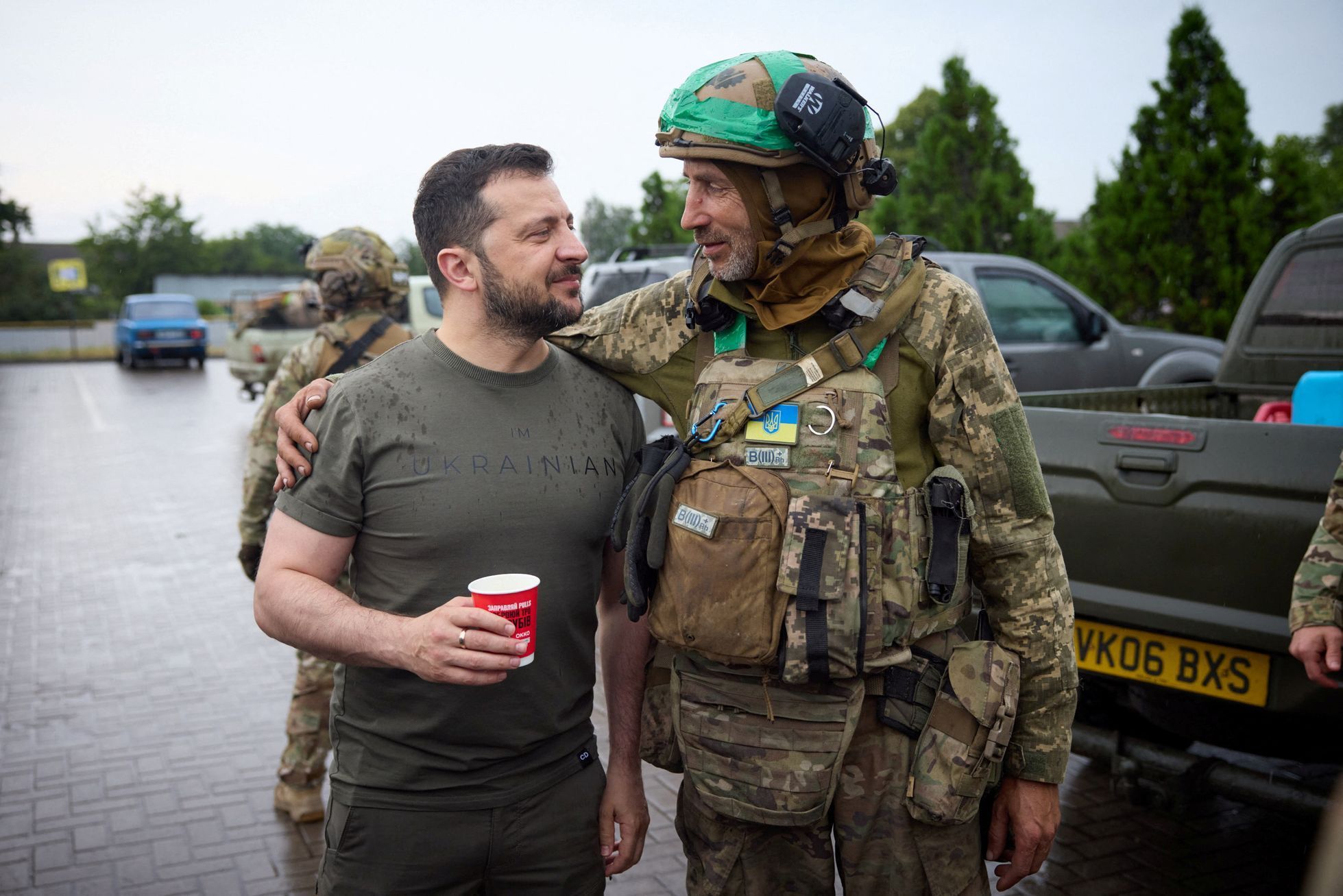 Volodymyr Zelenskyj popíjí kávu s ukrajinským vojákem během zastávky u čerpací stanice v Doněcké oblasti.