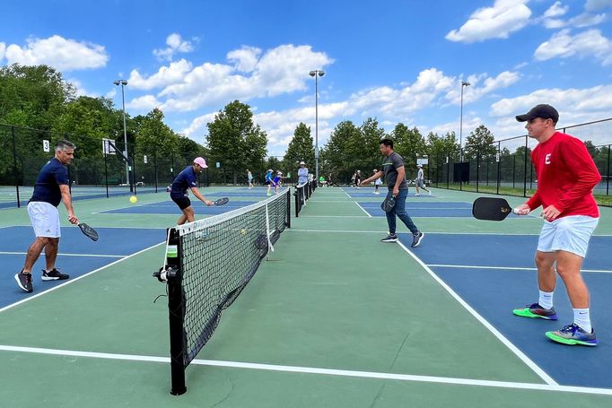 Profession pickleball player Ben Johns (2nd L), currently ranked number one in all three divisions of the sport, plays with his older brother Collin Johns (R), who is ran