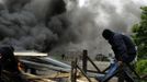 A coal miner makes a barricade next to burning tires in front of the main gate of the "Pozo Santiago" mine in Caborana, near Oviedo, northern Spain June 18, 2012. Spanish coal mining unions are taking part in a general strike in northern Spain mining areas to protest against government action to cut coal subsidies. REUTERS/Eloy Alonso (SPAIN - Tags: CIVIL UNREST BUSINESS EMPLOYMENT ENERGY) Published: Čer. 18, 2012, 1:10 odp.