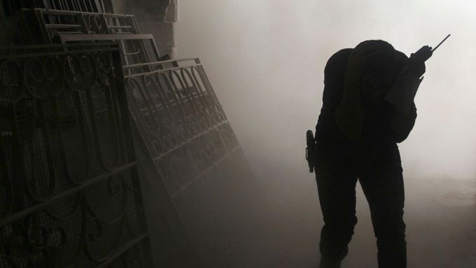 Příslušník povstalecké Svobodné syrské armády si zakrývá tvář při útoku vládních sil v Aleppu.