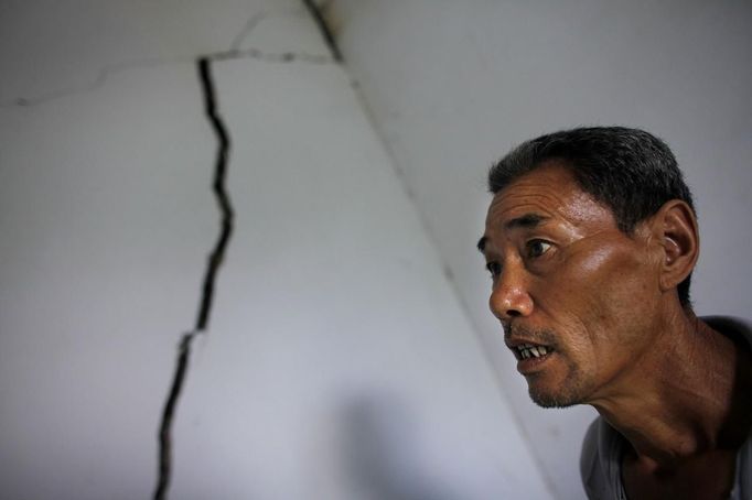 Ma Tianxin looks at the cracked walls of his house after a landslide near Badong, on the banks of the Yangtze River, 100km (62 miles) from the Three Gorges dam in Hubei province August 7, 2012. China relocated 1.3 million people during the 17 years it took to complete the Three Gorges dam. Even after finishing the $59 billion project last month, the threat of landslides along the dam's banks will force tens of thousands to move again. It's a reminder of the social and environmental challenges that have dogged the world's largest hydroelectric project. While there has been little protest among residents who will be relocated a second time, the environmental fallout over other big investments in China has become a hot-button issue ahead of a leadership transition this year. Picture taken on August 7, 2012. To match story CHINA-THREEGORGES/ REUTERS/Carlos Barria (CHINA - Tags: POLITICS ENVIRONMENT BUSINESS ENERGY) Published: Srp. 22, 2012, 8:16 odp.