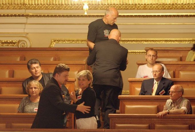 Ustavující schůzi sněmovnu narušila hlasitým křikem žena z galerie. Ochranka se s ní dlouho přetahovala, než se ji podařilo vyvést ven.