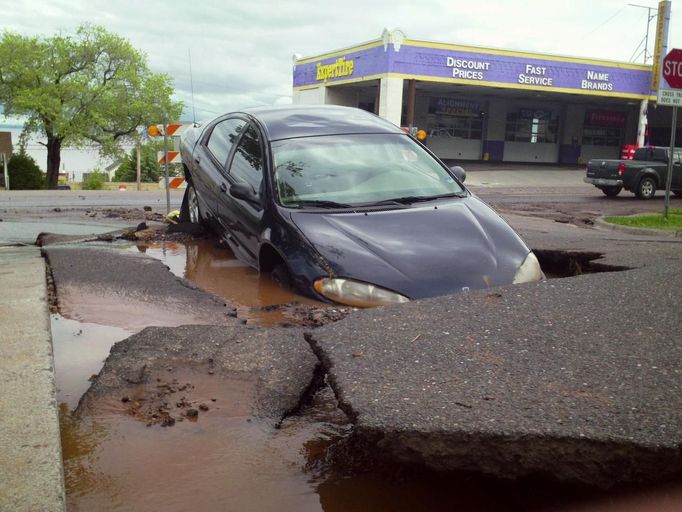 A car sits submerged in a street after flooding in Duluth, Minnesota, June 20, 2012. Heavy rains pounded northern Minnesota on Wednesday, forcing the evacuation of dozens of homes, causing mudslides and sinkholes, and swamping a zoo where several animals died, officials said. Picture taken June 20, 2012. REUTERS/Joe Cadotte (UNITED STATES - Tags: DISASTER SOCIETY ENVIRONMENT) Published: Čer. 21, 2012, 10:48 odp.