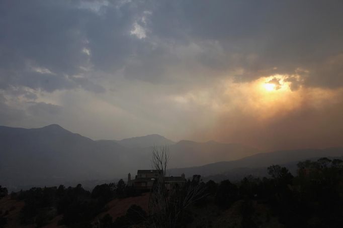 The setting sun is obscured by smoke from the Waldo Canyon fire west of Colorado Springs, Colorado June 24, 2012. Firefighters in Western U.S. states struggled to contain out-of-control wind-stoked wildfires across the U.S. west as summer temperatures mounted, and a fresh blaze consumed more homes in Colorado. REUTERS/Rick Wilking (UNITED STATES - Tags: DISASTER ENVIRONMENT) Published: Čer. 25, 2012, 1:01 dop.