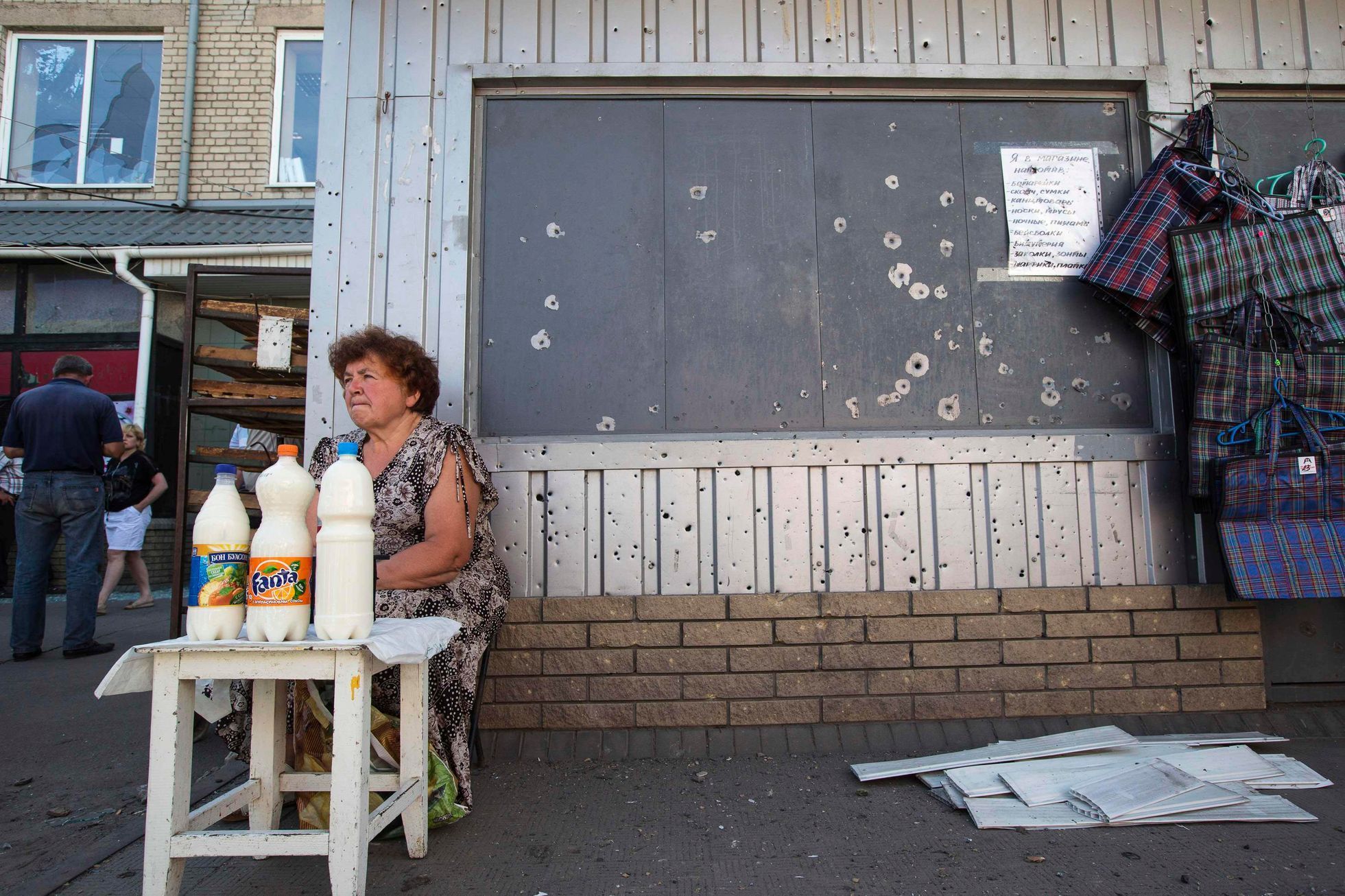 Slavjansk - žena prodává mléko u prostříleného obchodu