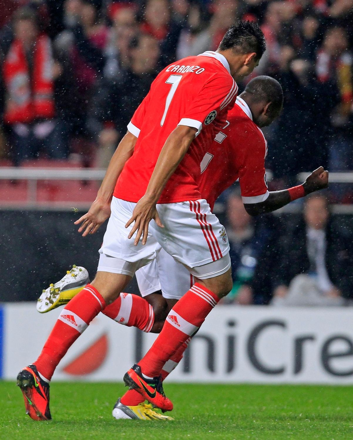 Fotbalisté Benficy Ola John (vpředu) a Oscar Cardozo slaví gól v utkání Ligy mistrů 2012/13 proti Celticu Glasgow.