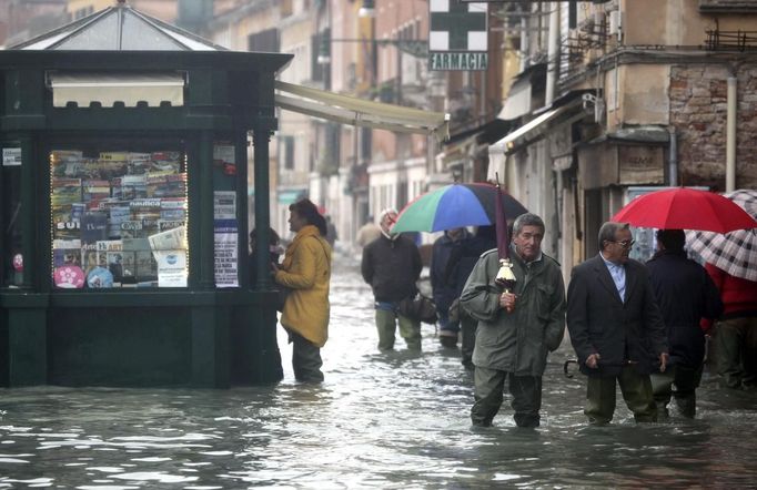 People walk in a flooded street during a period of seasonal high water in Venice November 1, 2012. The water level in the canal city rose to 140 cm (55 inches) above normal, according to the monitoring institute. REUTERS/Manuel Silvestri (ITALY - Tags: ENVIRONMENT SOCIETY) Published: Lis. 1, 2012, 1:23 odp.