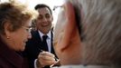 France's President and UMP party candidate for the 2012 French presidential elections Nicolas Sarkozy signs autographs for residents during a campaign visit to Valenciennes