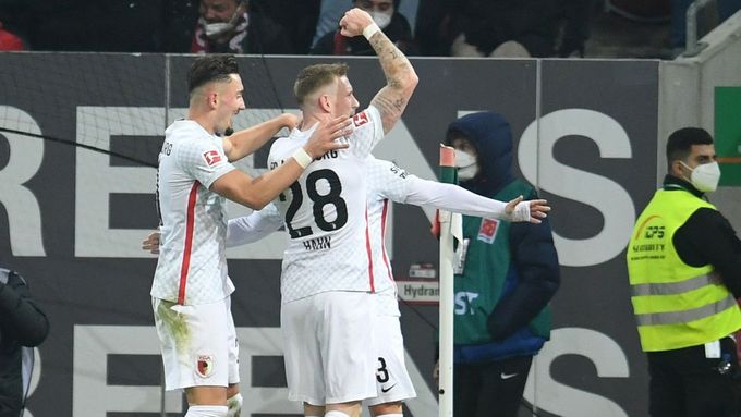 Fotbalisté Augsburgu slaví gól v síti Bayernu Mnichov.