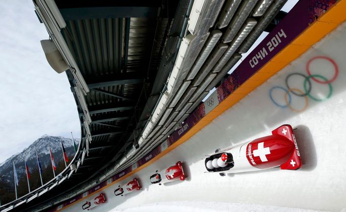 Switzerland's pilot Beat Hefti (front) and his teammates speed down the track during a four-man bobsleigh training session at the Sanki Sliding Center in Rosa Khutor, dur