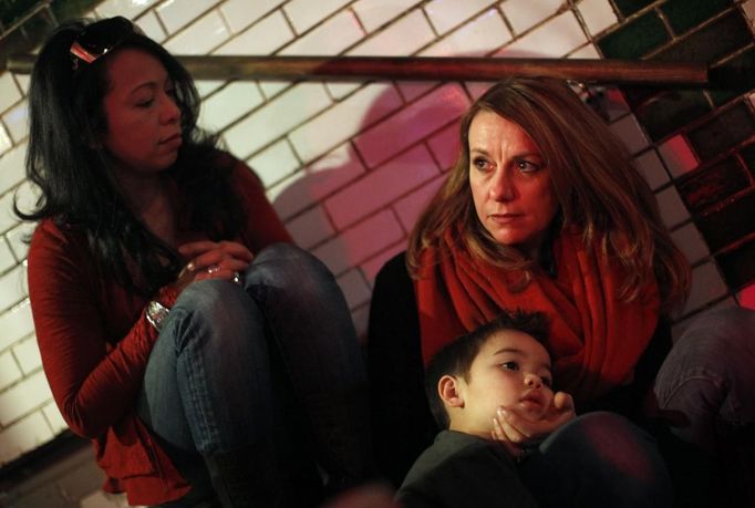 Jaidon Santos-Volpe rests his head on the hand of his mother Theresa Volpe as Mercedes Santos (L) watches at the "Beat Kitchen" in Chicago, Illinois, February 24, 2013. Santos and Volpe are a same-sex couple raising two of their biological children as they struggle to get same-sex marriages passed into law in Illinois. Picture taken February 24, 2013. REUTERS/Jim Young (UNITED STATES - Tags: SOCIETY) Published: Bře. 25, 2013, 6:08 odp.