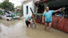 Local residents stand in a flooded courtyard of a house in the town of Krymsk, which has been seriously damaged by floods, in the Krasnodar region, southern Russia, July 8, 2012. Russian President Vladimir Putin ordered investigators to find out if enough was done to prevent 144 people being killed in floods in southern Russia after flying to the region to deal with the first big disaster of his new presidency. REUTERS/Eduard Korniyenko (RUSSIA - Tags: DISASTER ENVIRONMENT POLITICS) Published: Čec. 8, 2012, 11:41 dop.