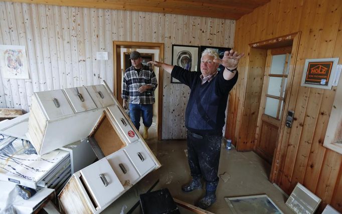 Wood mercantilist Walter Hundshammer, 73, rises his arms to demonstrate the height of the water levels of the nearby Danube river that devastated his house and his firm founded by his grandfather in 1909 in Natternberg, a suburb of the eastern Bavarian city of Deggendorf, June 10, 2013. REUTERS/Wolfgang Rattay (GERMANY - Tags: DISASTER ENVIRONMENT)