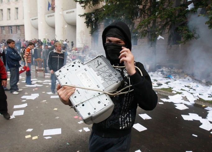 Demonstrant si odnáší svou "kořist" - tentokrát tiskárnu.