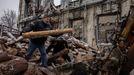 Men pile up wood for homes that are left without heating outside a courthouse that was destroyed by an airstrike, in the frontline town of Lyman, amid Russia's attack on