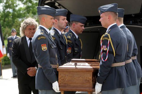 Vojáci úkládají rakev s ostatky do pohřebního vozu