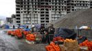 Women sell fruits and nuts near a construction site for the Sochi 2014 Winter Olympics within the perimeters of the Olympic Park in Adler, near Sochi February 18, 2013. Although many complexes and venues in the Black Sea resort of Sochi mostly resemble building sites that are still under construction, there is nothing to suggest any concern over readiness. Construction will be completed by August 2013 according to organizers. The Sochi 2014 Winter Olympics opens on February 7, 2014. REUTERS/Kai Pfaffenbach (RUSSIA - Tags: CITYSCAPE BUSINESS CONSTRUCTION ENVIRONMENT SPORT OLYMPICS) Published: Úno. 18, 2013, 6:20 odp.