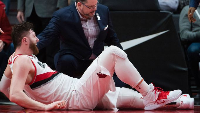 Mar 25, 2019; Portland, OR, USA; Portland Trail Blazers center Jusuf Nurkic (27) is attended to by a team trainer after injuring his leg during a second overtime against