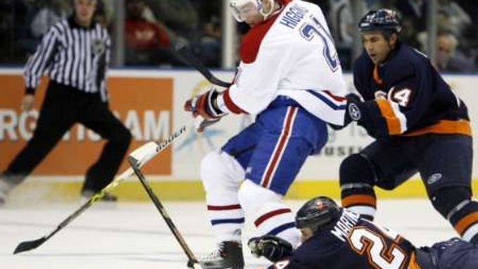 Centr Montrealu Christopher Higgins se v utkání NHL snaží uniknout dvěma bekům newyorských Islanders Radku Martínkovi (na ledě) a Chrisu Campolimu.