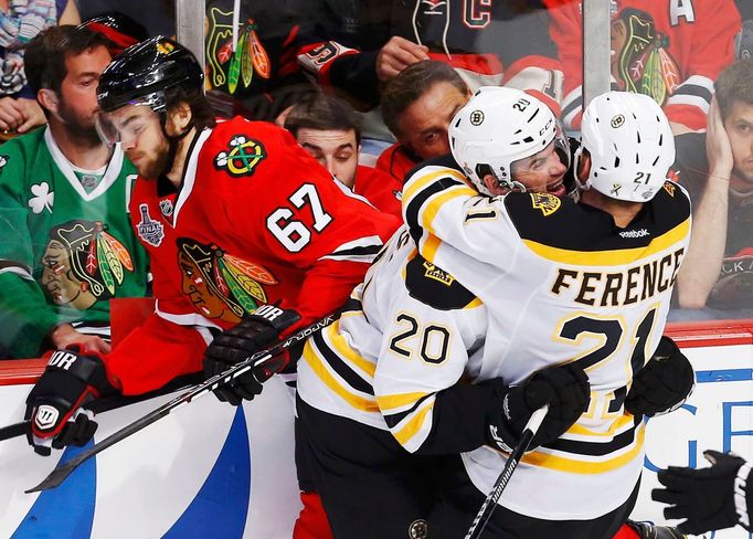 Boston Bruins' Daniel Paille (C) celebrates his overtime winning goal with teammate Andrew Ference as Chicago Blackhawks' Michael Frolik skates away during overtime in Ga