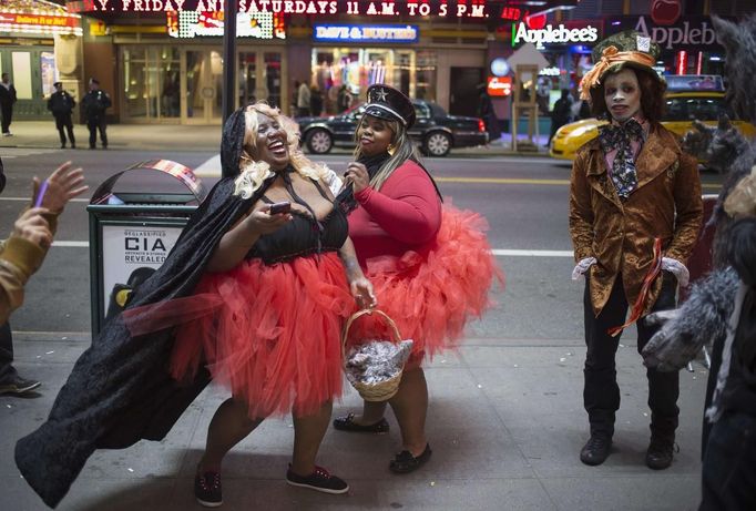 Revellers dressed up for Halloween share a laugh in Times Square, New York November 1, 2012. Mega-storm Sandy played Wicked Witch on Wednesday, postponing Halloween for millions of disappointed East Coast children warned not to trick or treat amid dangling electrical wires and trees uprooted by the deadly weather. REUTERS/Adrees Latif (UNITED STATES - Tags: SOCIETY DISASTER ENVIRONMENT) Published: Lis. 1, 2012, 8:25 dop.