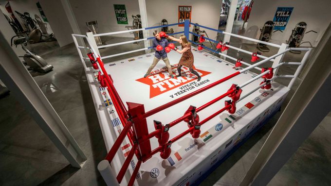 Boxerský ring místo značek sponzorů lemují symboly vlajek států, náboženství a korporací.