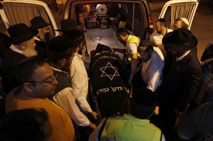 Israelis move the body of Aaron Smadja, one of the three Israelis killed by a rocket fired from Gaza, from a car before his funeral at a cemetery in the southern city of Kiryat Malachi November 15, 2012. Two rockets fired from the Gaza Strip targeted Tel Aviv on Thursday in the first attack on Israel's commercial capital in 20 years, raising the stakes in a showdown between Israel and the Palestinians that is moving towards all-out war. REUTERS/Ronen Zvulun (ISRAEL - Tags: CIVIL UNREST POLITICS) Published: Lis. 15, 2012, 7:34 odp.