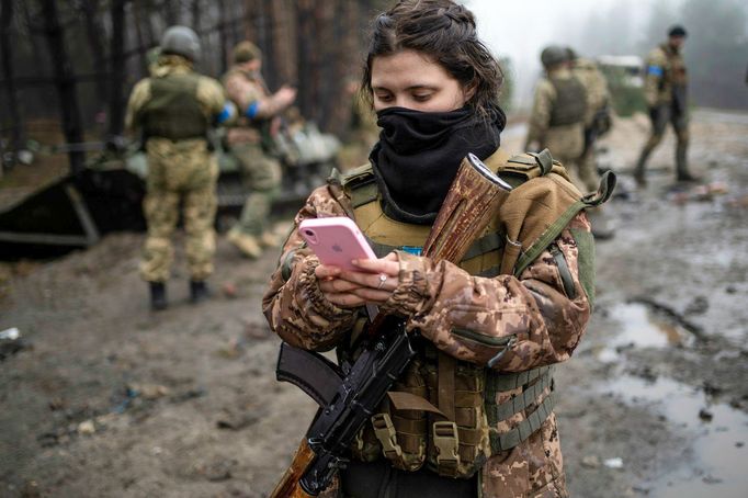 Fotografie ženy během ruské invaze na Ukrajinu v ukrajinské armádě na předměstí Kyjeva. Datum pořízení snímku: 1. 4. 2022.