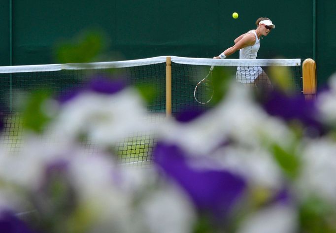 Samantha Stosur of Australia hits a return to Olga Puchkova of Russia in their women's singles tennis match at the Wimbledon Tennis Championships, in London June 27, 2013