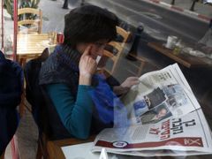 Žena si v jeruzalemské kavárně čte článek o vězni X v deníku Jediot Achronot.