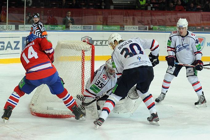 Hokejista Lva Praha Jaroslav Svoboda v šanci před bránícími Alexandrem Nikulinem, Artursem Kuldou a brankářem Jeffem Glassem v utkání KHL 2012/13 proti Novosibirsku.