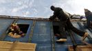 A woman looks out of the bus window at a man climbing on the outside, in Sevare January 26, 2013. REUTERS/Eric Gaillard (MALI - Tags: CIVIL UNREST SOCIETY TPX IMAGES OF THE DAY) Published: Led. 26, 2013, 6:40 odp.