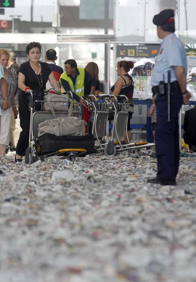 A passenger pushes a trolley during a protest by the cleaning staff at Barcelona's airport May 29, 2012. Cleaning staff working for a company which has a contract with the airport demonstrated against pay and benefits cuts made by their employer. REUTERS/Albert Gea (SPAIN - Tags: CIVIL UNREST BUSINESS TRANSPORT) Published: Kvě. 29, 2012, 5:27 odp.