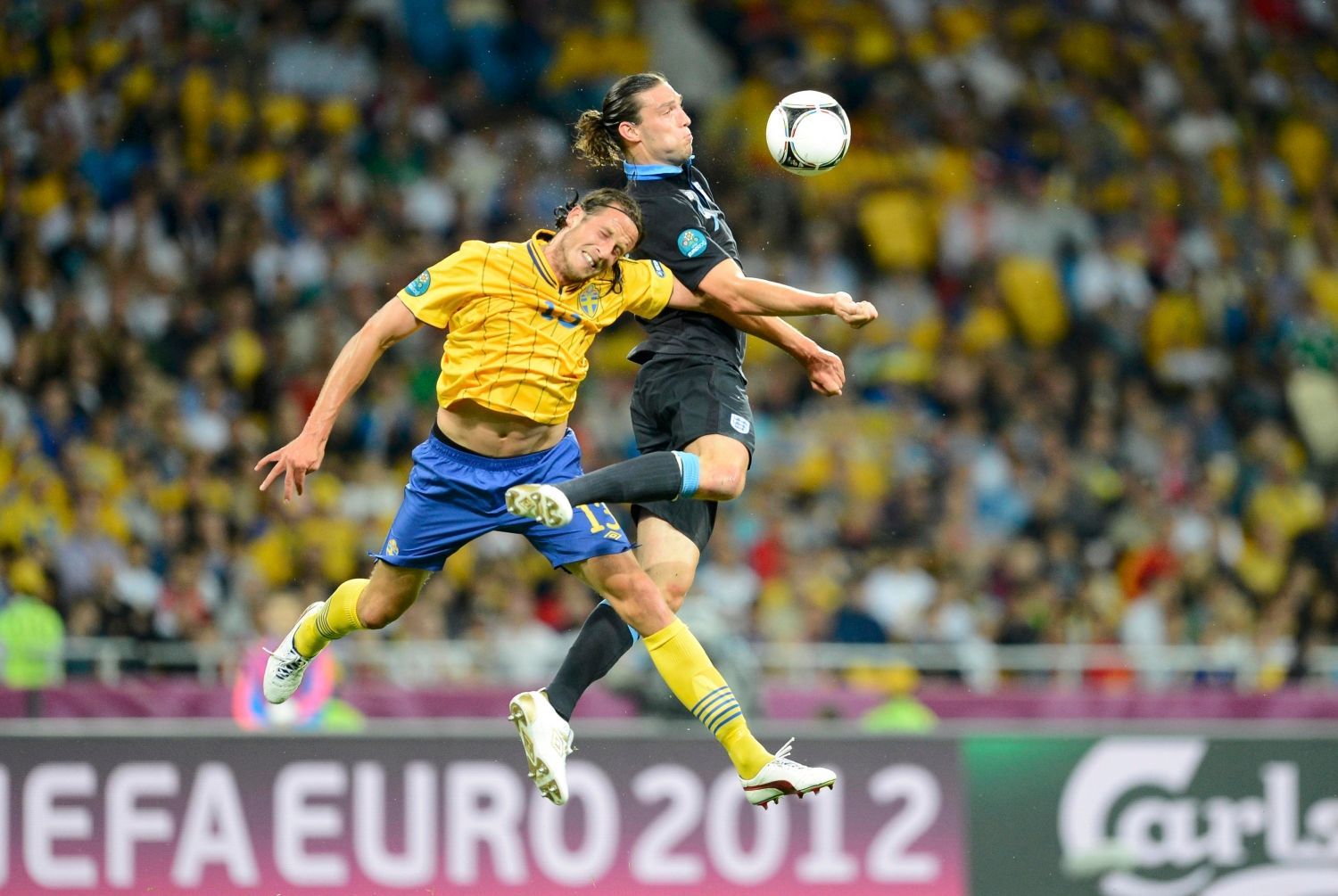 Švédský fotbalista Jonas Olsson se snaží zamezit Angličanu Andymu Carrollovi ve zpracování si míče v utkání skupiny D na Euru 2012