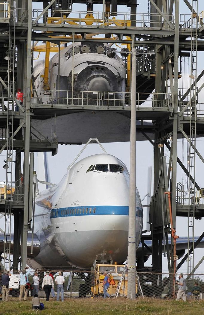 Space center workers watch as space shuttle Discovery is approached by a converted NASA 747 aircraft which is being towed into the Mate Demate facility at Kennedy Space Center in Cape Canaveral