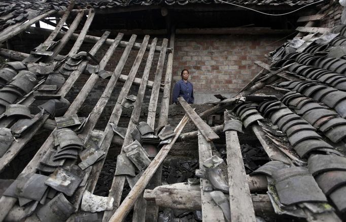 A survivor reacts as she stands in her damaged house after a strong 6.6 magnitude earthquake hit Lushan county of Ya'an, Sichuan province April 21, 2013. Rescuers poured into a remote corner of southwestern China on Sunday as the death toll from the country's worst earthquake in three years climbed to 164 with more than 6,700 injured, state media said. REUTERS/Jason Lee (CHINA - Tags: DISASTER ENVIRONMENT) Published: Dub. 21, 2013, 5:36 dop.