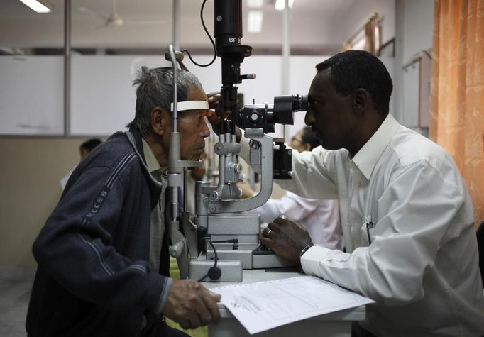 Ethiopian doctor Fikru Melka (R) checks his patient's eyes at the Tilganga Eye Center in Kathmandu April 26, 2012. About 150,000 of Nepal's 26.6 million people are estimated to be blind in both eyes, most of them with cataracts. Picture taken April 26, 2012. REUTERS/Navesh Chitrakar (NEPAL - Tags: HEALTH SOCIETY POVERTY) Published: Kvě. 2, 2012, 4:57 dop.