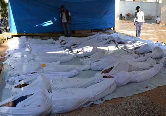 Syrský aktivista nad těly lidí, kteří podle tvrzení opozice zemřeli při chemickém útoku na damašské předměstí Ghúta. (21. srpna 2013)