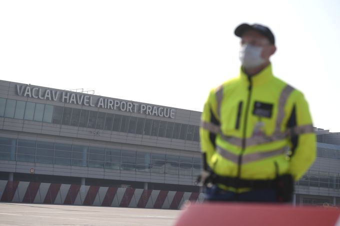 Pracovník pražského letiště Václava Havla v ochranné masce