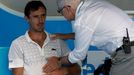 Doctor checks on Roger-Vasselin of France during a medical timeout in play in his men's singles match against Anderson of South Africa at Australian Open 2014 tennis tour