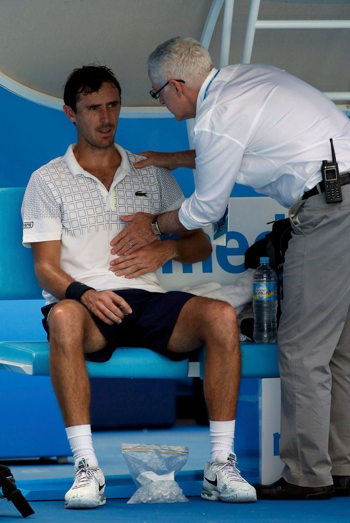 Doctor checks on Roger-Vasselin of France during a medical timeout in play in his men's singles match against Anderson of South Africa at Australian Open 2014 tennis tour