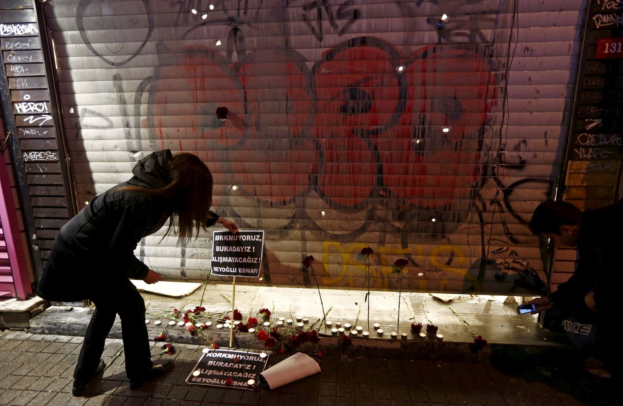 Žena v Istanbulu zapaluje svíčku za oběti teroristického útoku